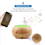 A wood aroma diffuser with bluetooth speaker music playing