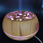 an aroma diffuser wood color is running with mist upward
