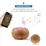 a mobile controls a essential oil diffuser bluetooth in wood color