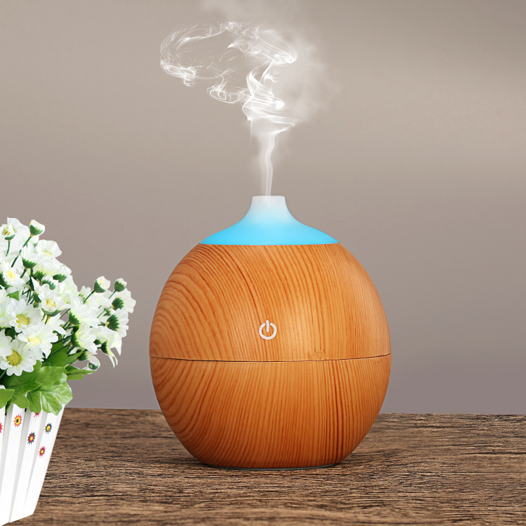 a light wood color humidifier for desk is running with mist upward