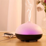 a wood base usb aromatherapy diffuser is runing on desktop