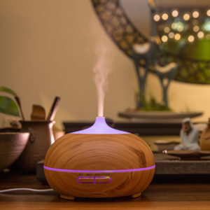 a wood color ultrasonic aroma diffuser is running with mist upward