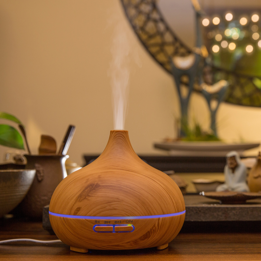 a light wood color essential oil diffuser 500ml is running with mist upward