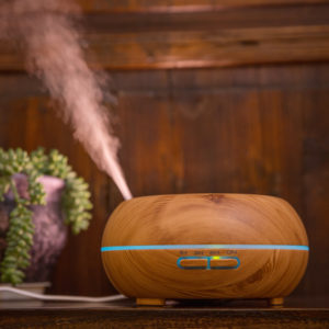 a wood color room aroma diffuser running with mist upward