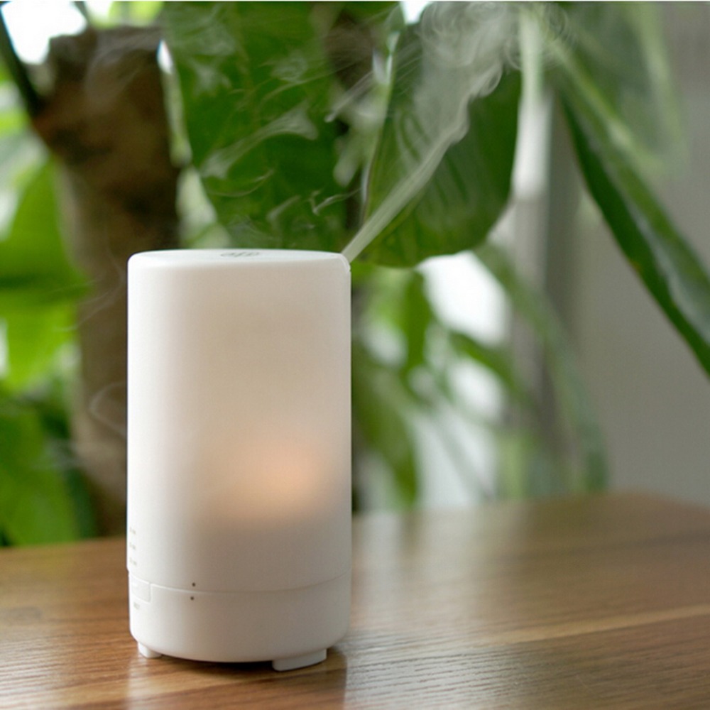 a white color muji portable aroma diffuser is running with mist on desktop