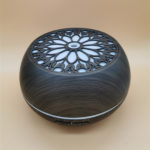an electric aromatherapy diffuser in dark wood color