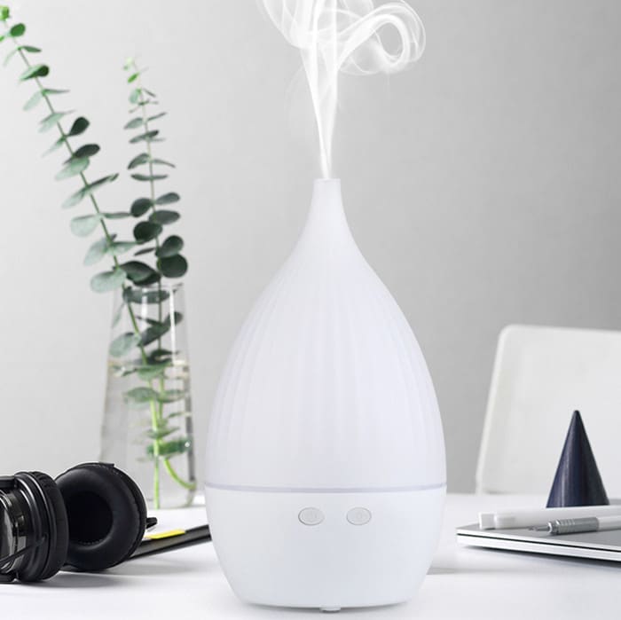 a white color usb aroma diffuser running with mist