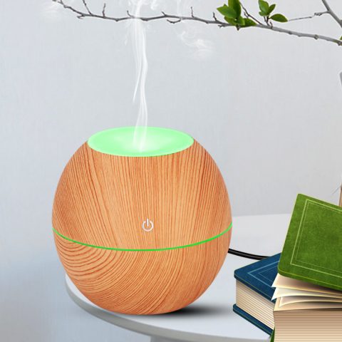 a wood color mini desk humidifier is running with mist