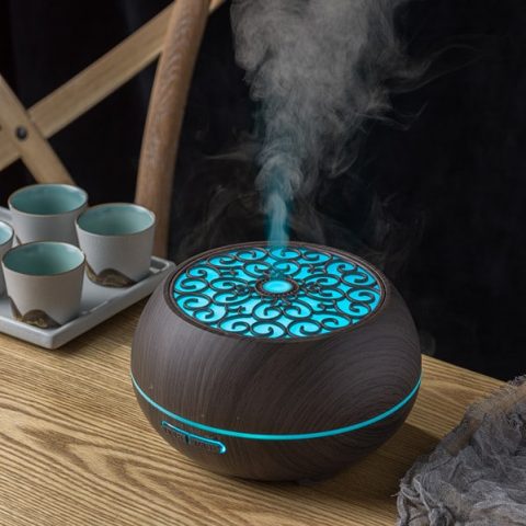 a dark color wood aroma diffuser is running with mist